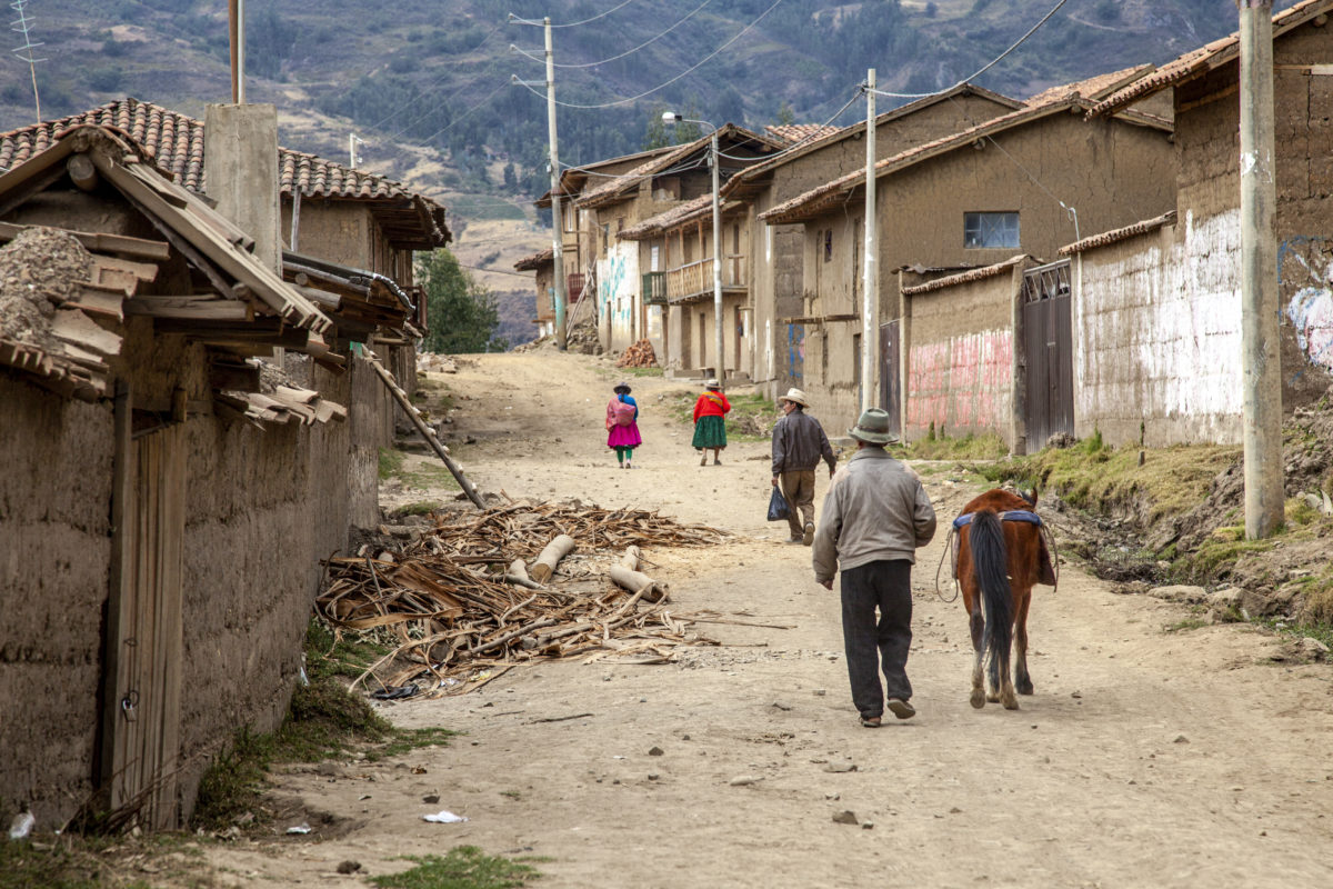 Locals walk down the street on the edge of San Luis District, Peru, in the Andes Mountains.